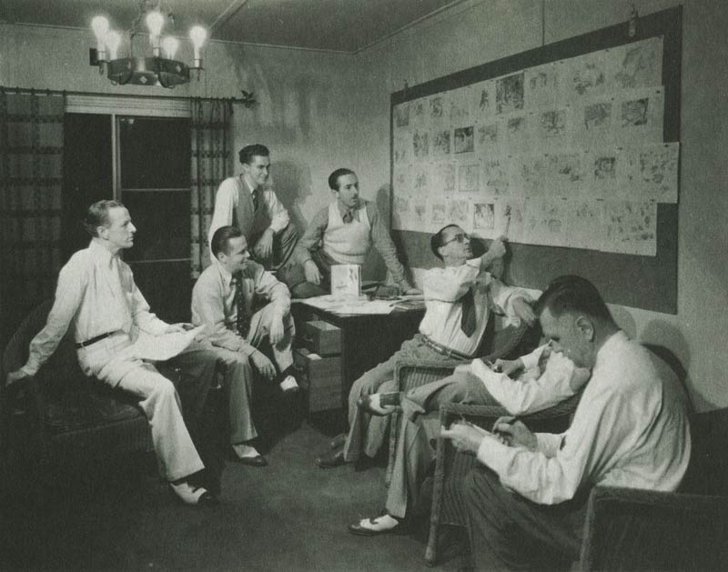 group of original Disney animators pointing at a Storyboard
